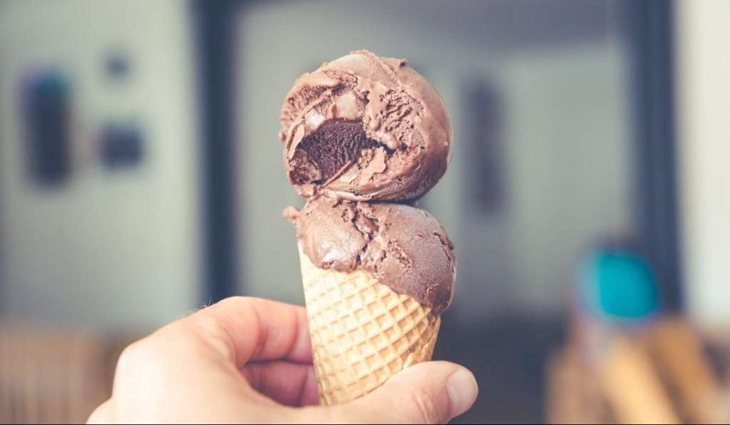 person holding chocolate ice cream cone