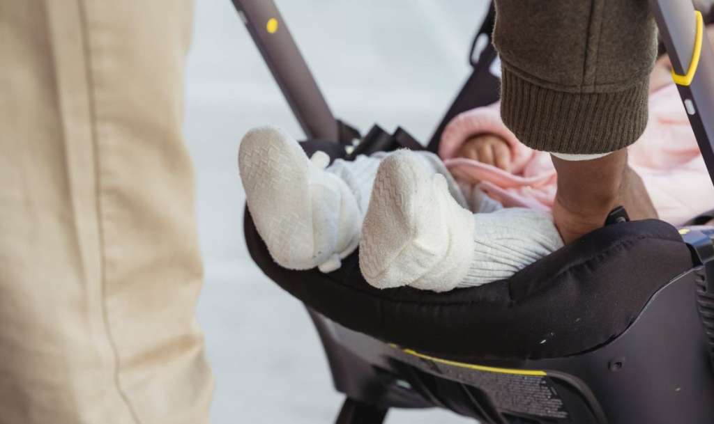 crop unrecognizable black father caressing newborn baby in stroller