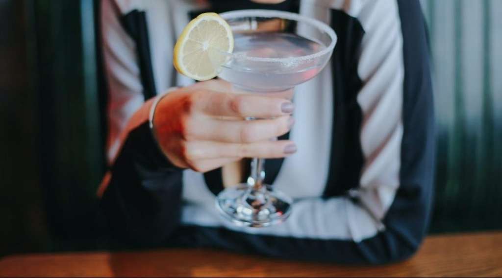 close up of smiling woman holding cocktail