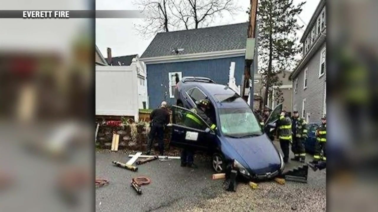 WATCH Everett crash sends car through fence, leaves it perched on wall